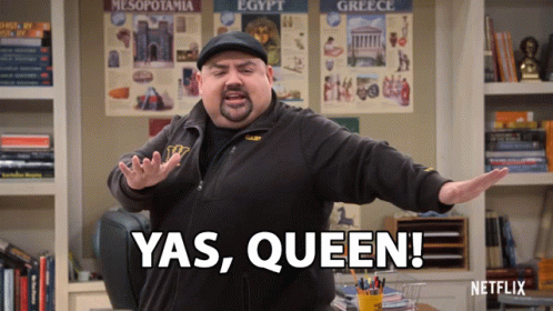 A Man Says Yas Queen In Front Of A Shelf Full Of Books GIF