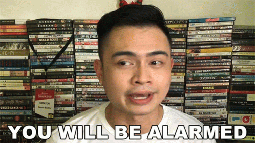 Man Saying You Will Be Alarmed In Front Of DVDs GIF