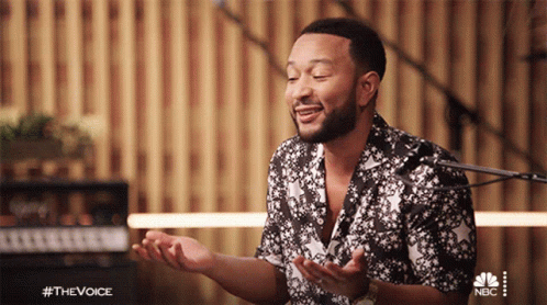 A Man Singing In Front Of A Microphone With The Hashtag #Thevoice On The Bottom Right GIF