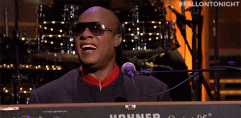 A Man Singing Into A Hohner Keyboard With The Hashtag #Fallontonight GIF