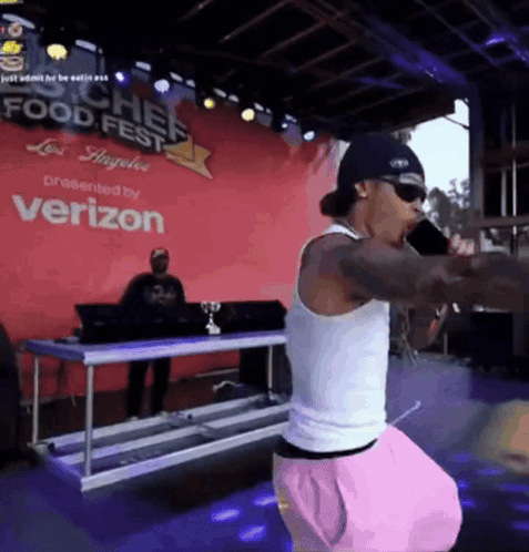 A Man Singing Into A Microphone At A Food Fest GIF