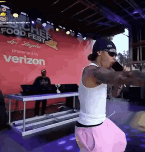 A Man Singing Into A Microphone At A Food Fest GIF