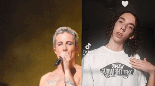 A Man Singing Into A Microphone Next To Another Man Wearing A White Vans Shirt GIF