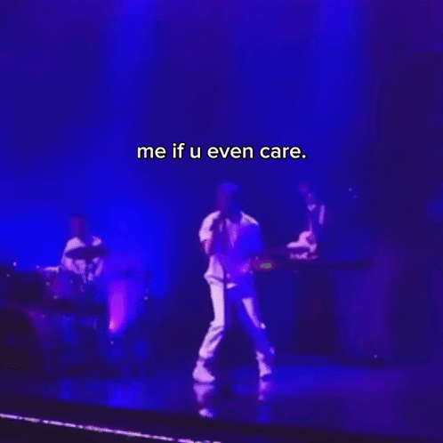 A Man Singing Into A Microphone On A Stage With The Words Me If U Even Care On The Bottom GIF
