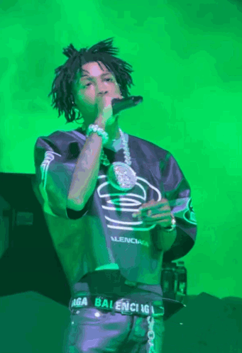 A Man Singing Into A Microphone Wearing A Balenciaga Belt GIF