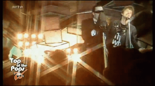 A Man Singing Into A Microphone While Wearing A Shirt That Says " I 'M With " GIF
