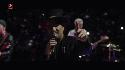 a man singing into a microphone with a red circle that says dr on it