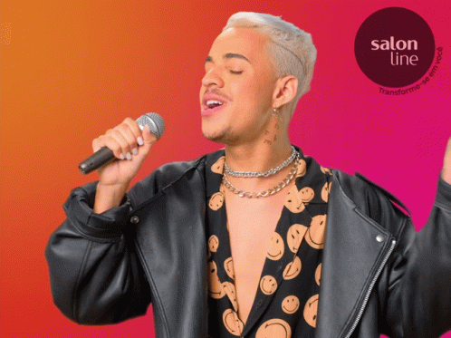a man singing into a microphone with a salon line logo in the corner