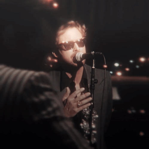 A Man Singing Into A Microphone With His Eyes Closed GIF