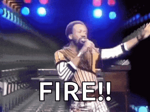 a man singing into a microphone with the word fire written on it