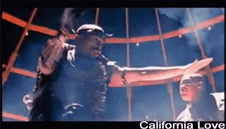 A Man Singing Into A Microphone With The Words California Love Written Below Him GIF