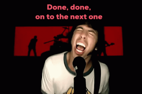 A Man Singing Into A Microphone With The Words " Done Done On To The Next One " Behind Him GIF