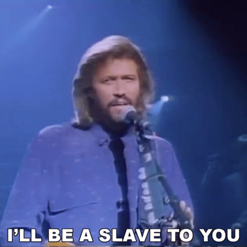 A Man Singing Into A Microphone With The Words " I 'Ll Be A Slave To You " Next To Him GIF
