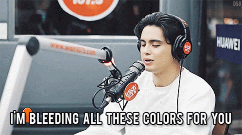 A Man Singing Into A Microphone With The Words I 'M Bleeding All These Colors For You GIF