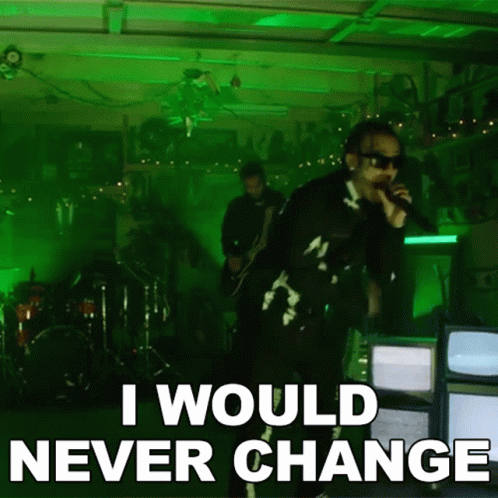 A Man Singing Into A Microphone With The Words " I Would Never Change " Below Him GIF