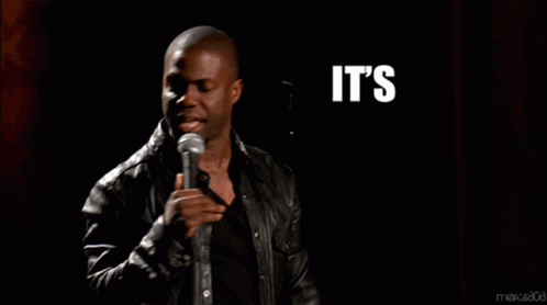 a man singing into a microphone with the words it 's about to go down above him