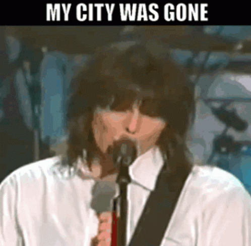 A Man Singing Into A Microphone With The Words " My City Was Gone " Above Him GIF