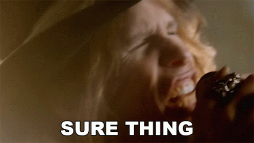 A Man Singing Into A Microphone With The Words " Sure Thing " Behind Him GIF