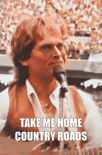 A Man Singing Into A Microphone With The Words Take Me Home Country Roads Above Him GIF