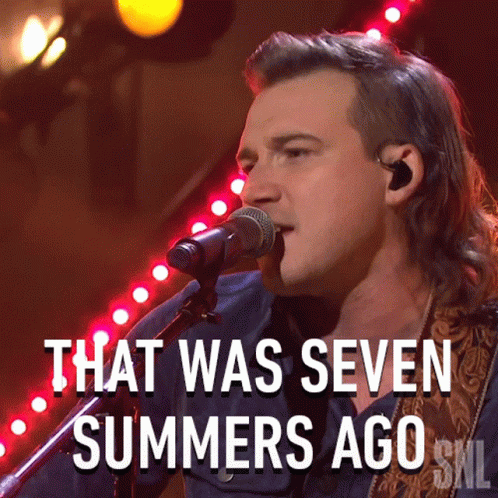 A Man Singing Into A Microphone With The Words That Was Seven Summers Ago Below Him GIF
