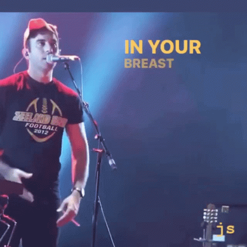 A Man Singing Into A Microphone With The Words " The Heart Of The Earth " Below Him GIF