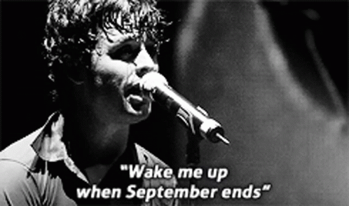 a man singing into a microphone with the words " wake me up when september ends " on the bottom