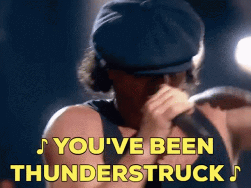 A Man Singing Into A Microphone With The Words You 'Ve Been Thunderstruck Written In Yellow GIF