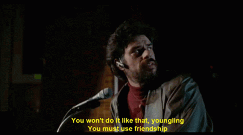a man singing into a microphone with the words you won 't do it like that youngling you must use friendship