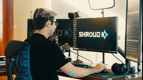 A Man Sits At A Desk With A Computer Monitor That Says Shroud On It GIF