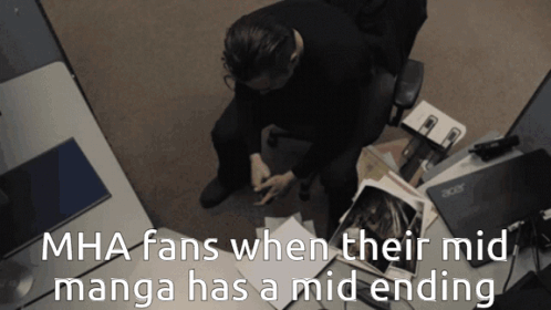A Man Sits At A Desk With Acer Laptops And Papers GIF