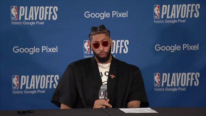 A Man Sits At A Table In Front Of A Wall That Says Playoffs GIF