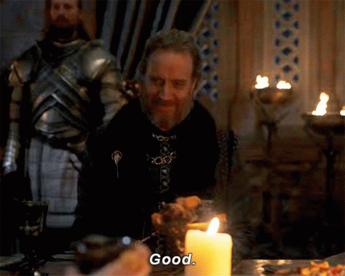 a man sits at a table with a candle and says " good "