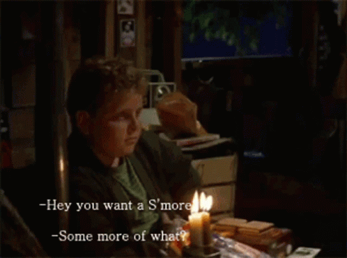 a man sits at a table with a lit candle and says hey you want a s'more -some more of what