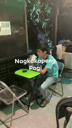 a man sits at a table with a sign that says clean as you go behind him