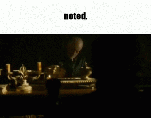 A Man Sits At A Table With Candles And The Words Noted Below Him GIF