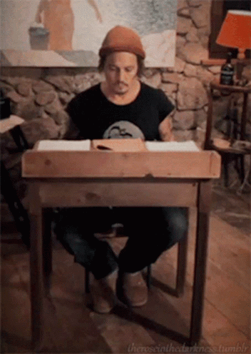 A Man Sits At A Wooden Desk With The Words " The Social Darkness Tumblr " On The Bottom Right GIF