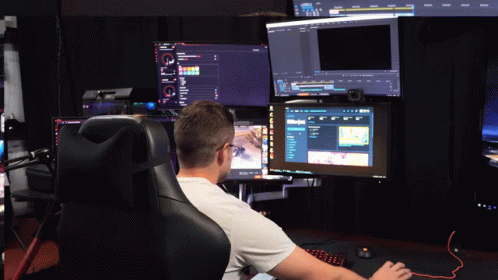 A Man Sits In A Chair In Front Of A Computer Monitor That Says ' A ' On It GIF