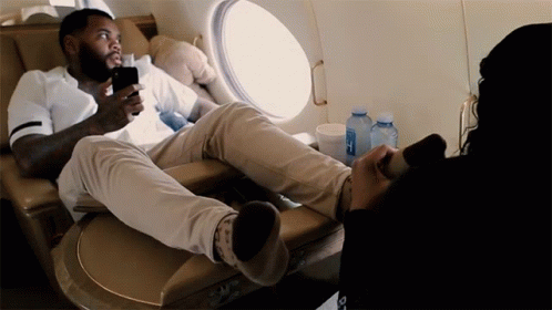 A Man Sits In A Chair With His Feet Up And A Bottle Of Aquafina Water In Front Of Him GIF