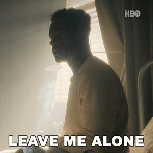 a man sits in a dark room with the words " leave me alone " on the bottom