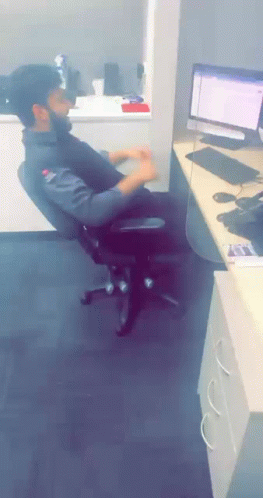A Man Sits In An Office Chair In Front Of A Computer Screen GIF