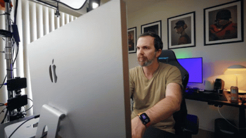 A Man Sits In Front Of A Large Apple Monitor GIF