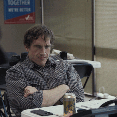 A Man Sits In Front Of A Sign That Says Together We Are Better GIF