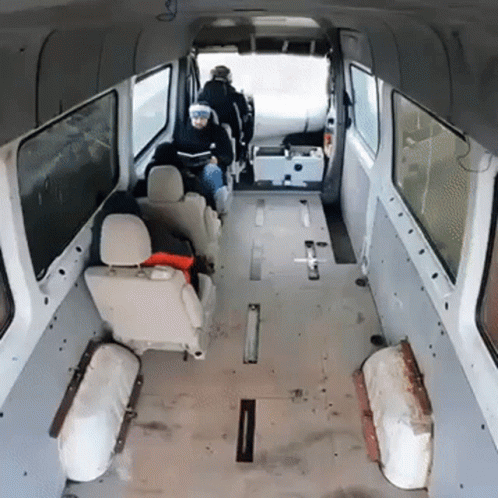A Man Sits In The Back Of A Van Looking At His Phone GIF