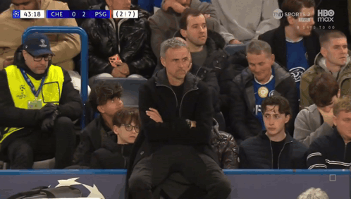 A Man Sits In The Stands Watching A Soccer Game Between Che And Psg GIF