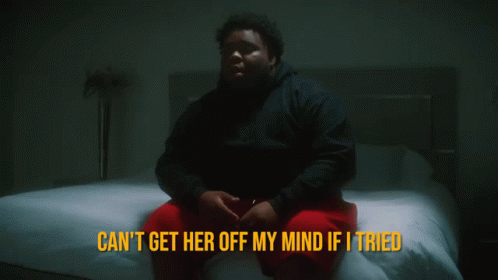 A Man Sits On A Bed With The Words " Can 'T Get Her Off My Mind If I Tried " Above Him GIF
