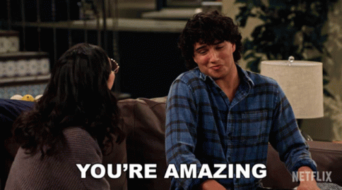 A Man Sits On A Couch With A Woman And Says You 'Re Amazing On The Screen GIF