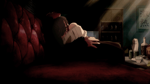 A Man Sits On A Red Couch In A Dark Room With Chinese Writing On The Wall Above Him GIF