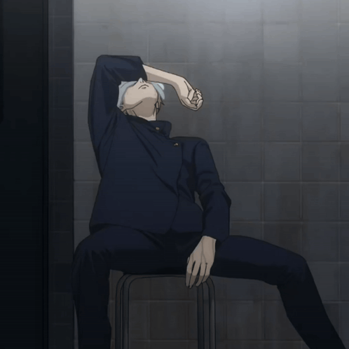 A Man Sits On A Stool With His Head Down GIF