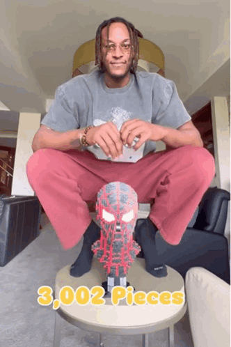 A Man Sits On A Table With A Spider Man Mask On It And Says 3,000 Pieces GIF