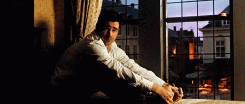 A Man Sits On The Floor In Front Of A Window GIF